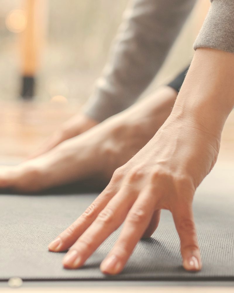 Hand auf der roten Yogamatte